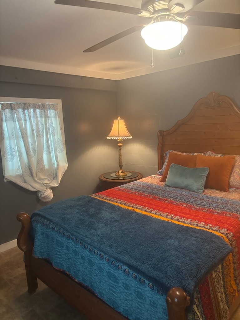 Bedroom with queen bed, wood headboard and colorful bedding at Mountain Point of View Cottage